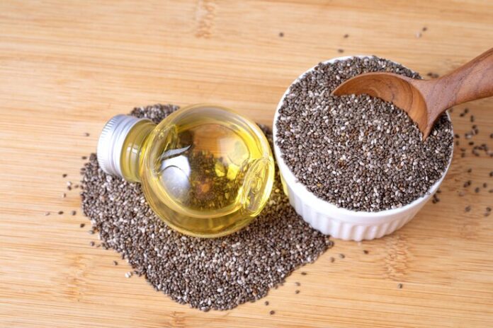 close-up-chia-essential-oil-seeds-wooden-spoon_25381-704